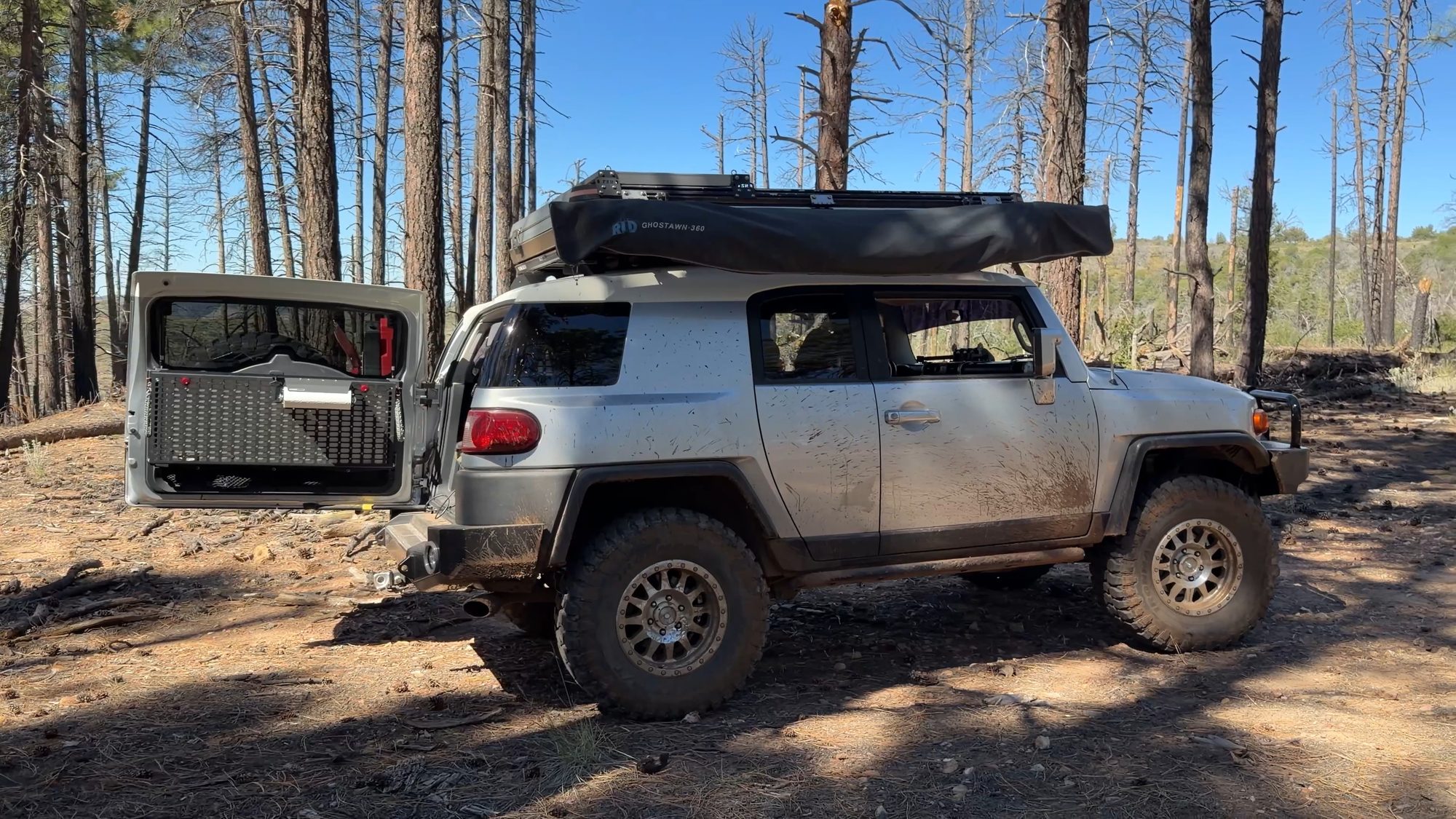 Silver FJ Cruiser with a rooftop tent