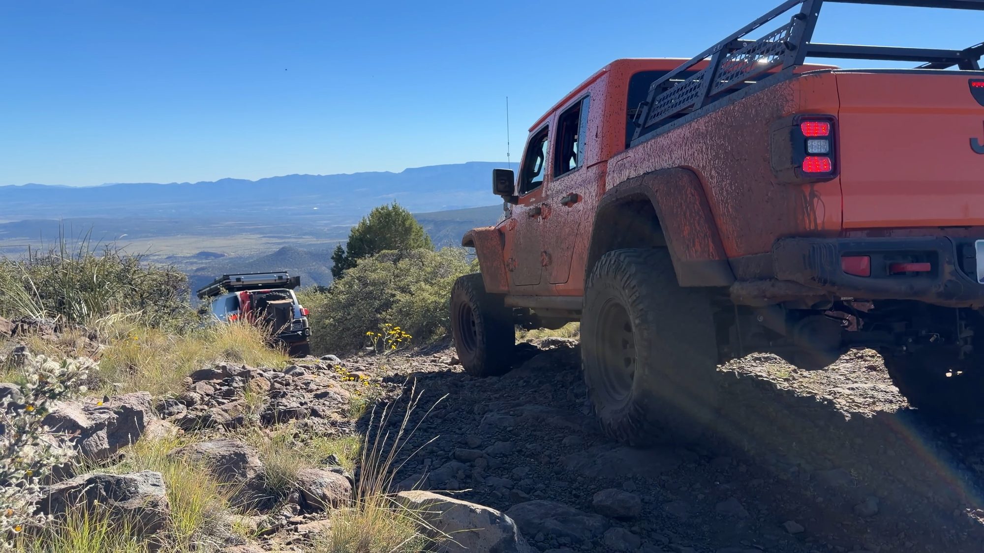 Orange Jeep Gladiator on a rocky descent
