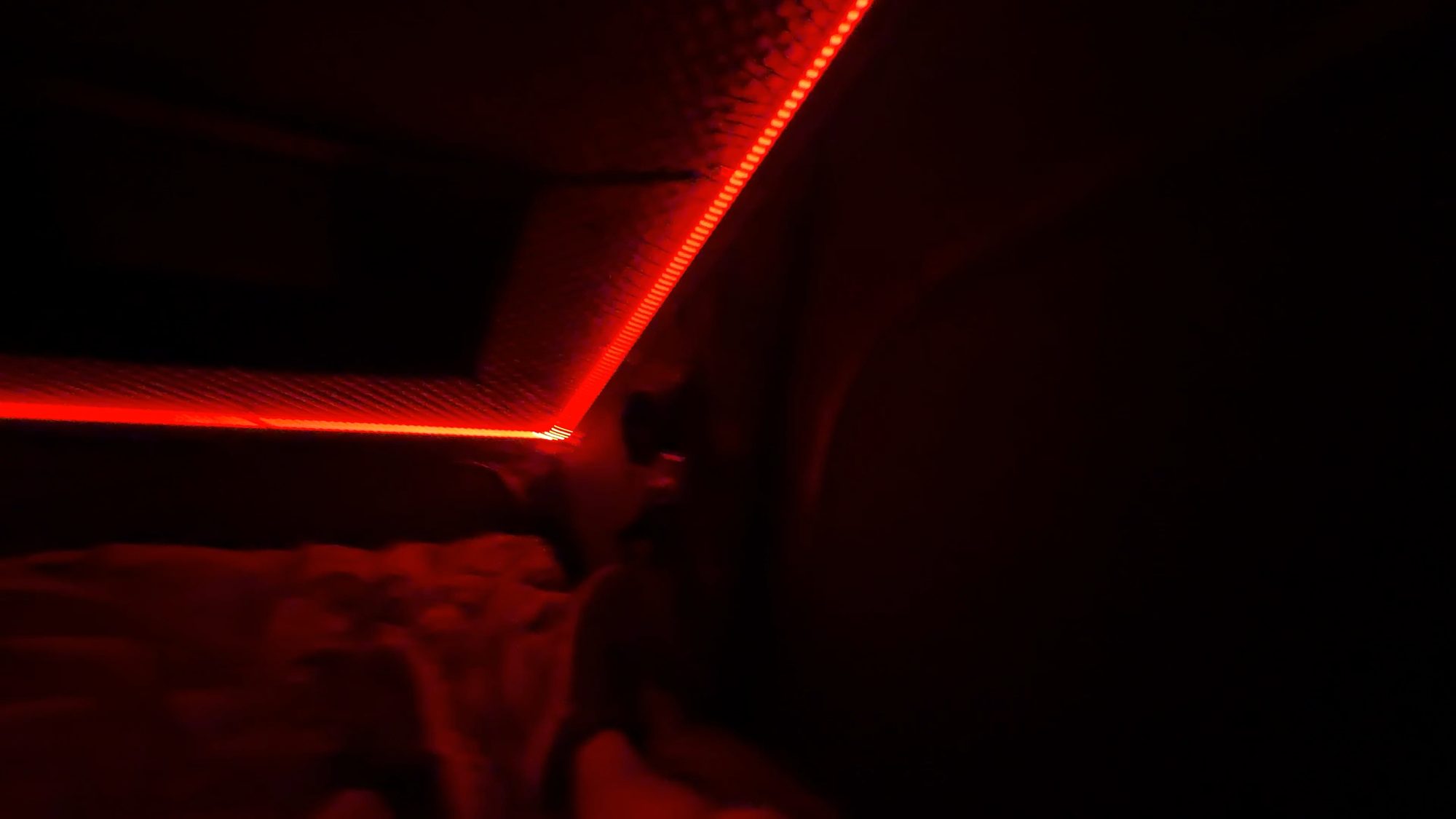 Red LED lights inside a dark rooftop tent