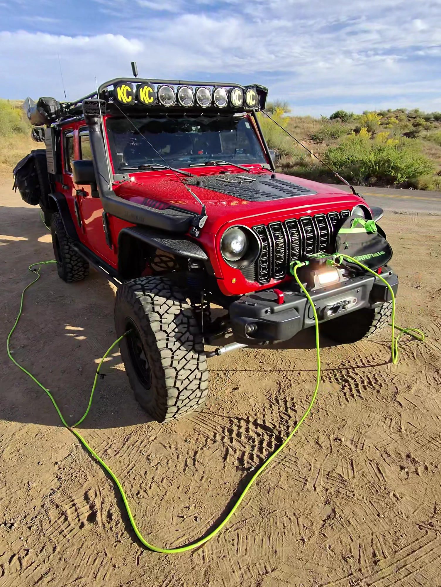 Red Jeep Wrangler with yellow MORRFlate hoses running to each tire at a dirt pullout off the Crown King Road