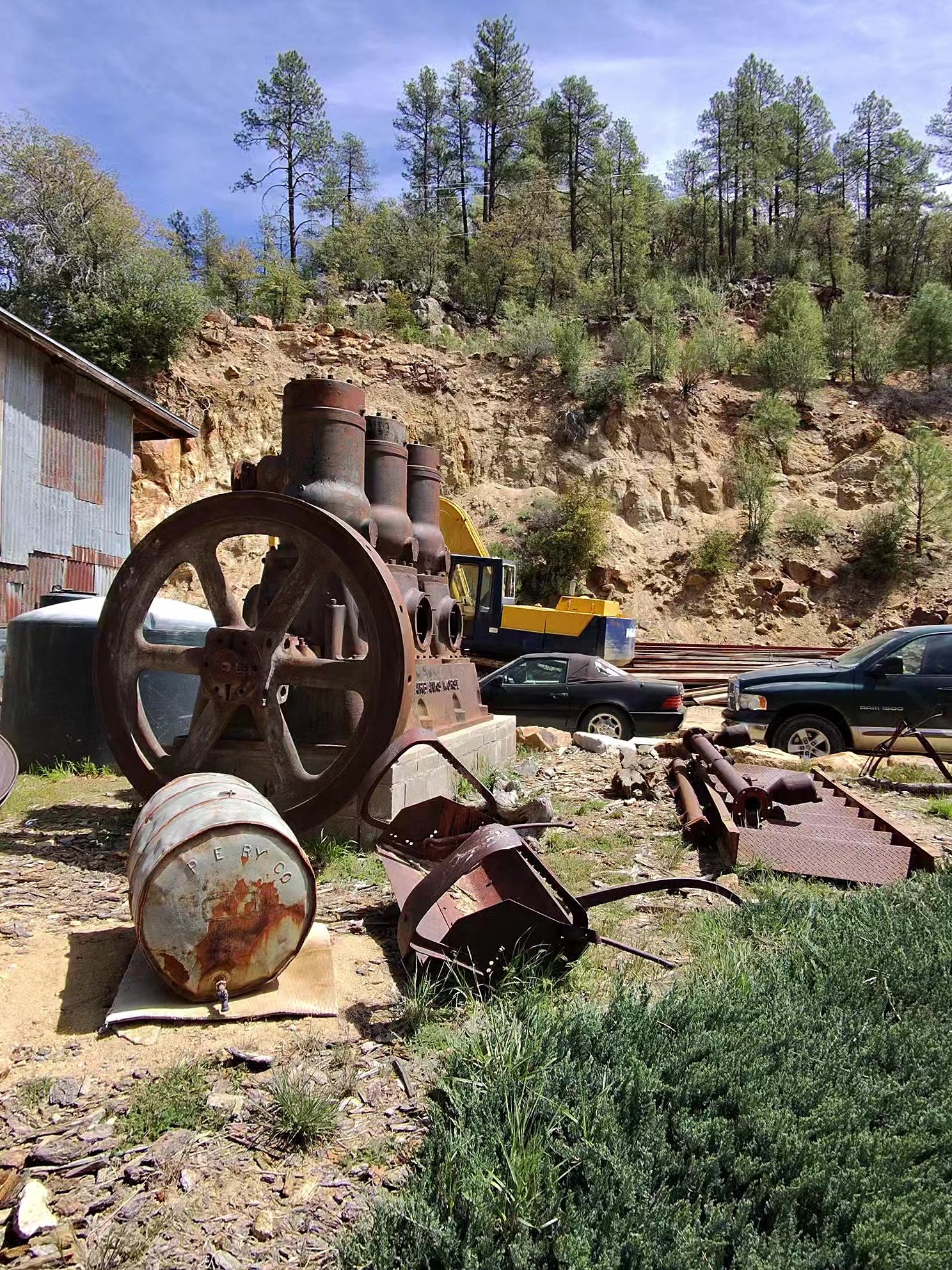 Rusted antique mining engine with a large flywheel displayed outside The Mill