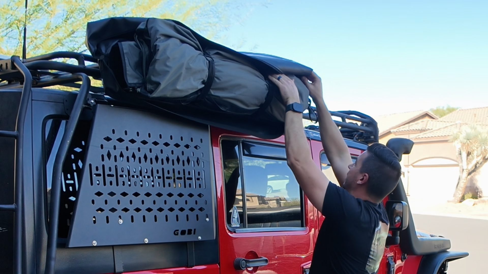 Josh rolling the Taruca ensuite canvas back into its cover on the Jeep roof rack